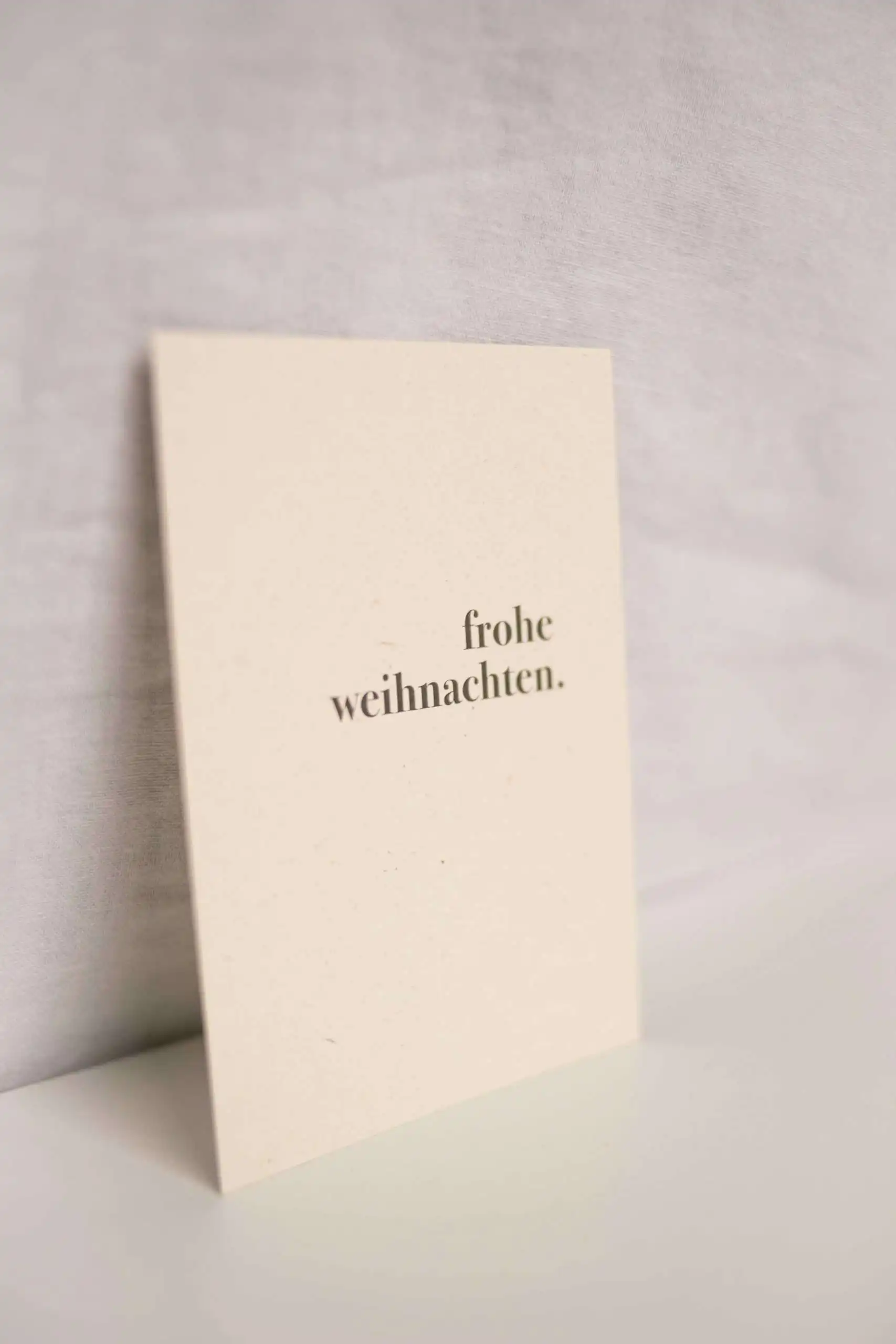 Besinnliche Weihnachtskarte mit "Frohe Weihnachten" in deutschem Design.