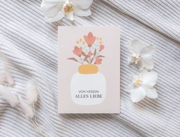 Schlichte Grußkarte mit Blumenmotiv und liebevollen Spruch auf weißem Stoffhintergrund.