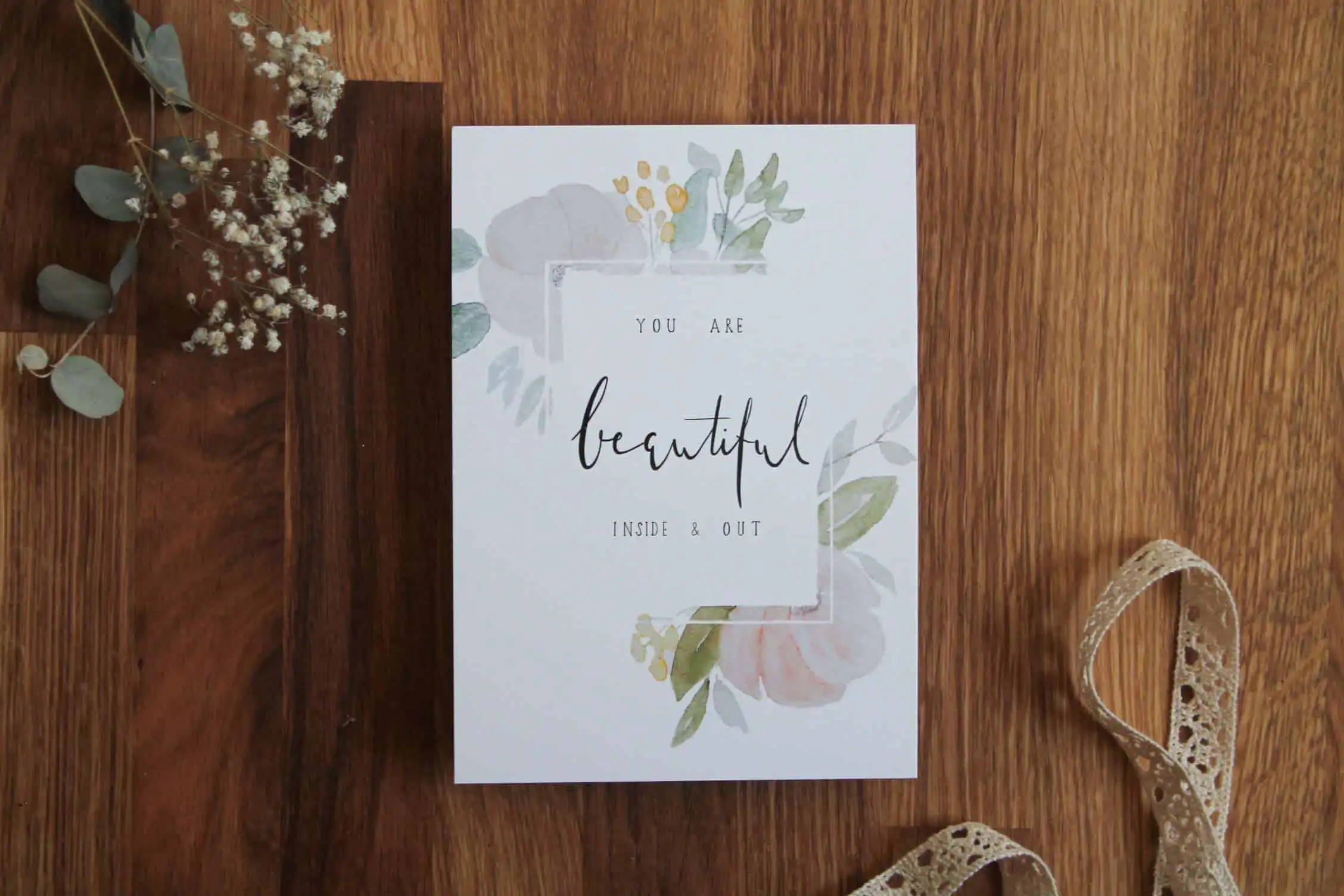 Schöne christliche Grußkarte mit Blumenmotiven auf Holztisch.