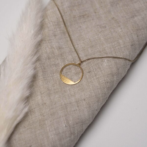 Elegantes christliches Schmuckstück mit graviertem Kreuzanhänger auf Leinenstoff.