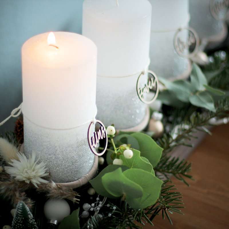 Zahlenringe für den Adventskranz 2 Gemütliche Osterdekoration mit Kerzen und grünen Zweigen.