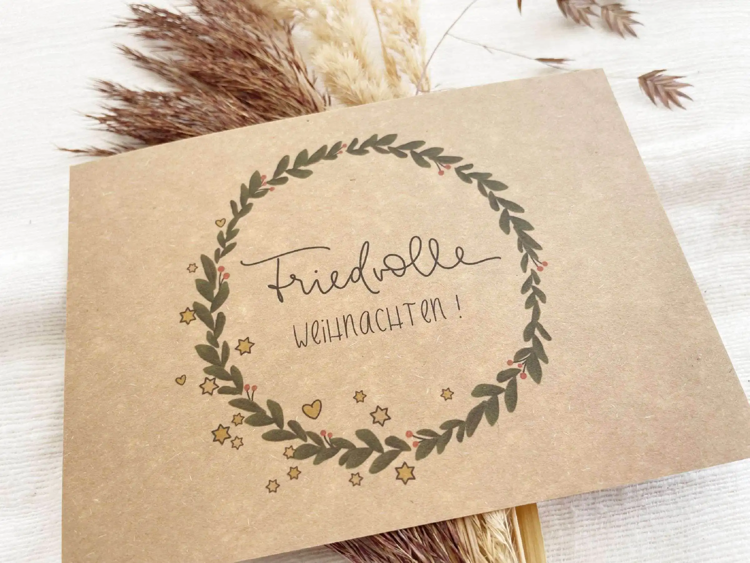 Friedvolle Weihnachtsgrüße auf handgemachter Karte mit Naturdeko.