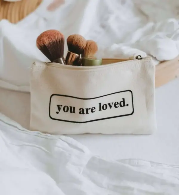 Sanfte Make-up Pinsel in einer Stofftasche mit „you are loved“-Slogan, christliche Geschenkidee.
