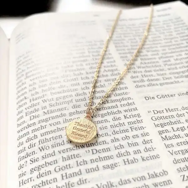 Glaubensarmband mit christlichem Spruch auf goldener Kette, religiöse Schmuckaccessoires.