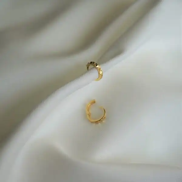 Goldohrringe mit Textur, elegante Accessoires für christlichen Stil.