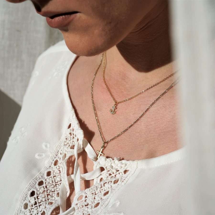 Minimalistische christliche Kette MINIMALISTIC ANCHOR von FIRSTGOD bei mookho aus vergoldetem 925 Sterling Silber mit Zirkonia-Steinchen. Die christliche Kette wird von einer Frau um den Hals getragen.