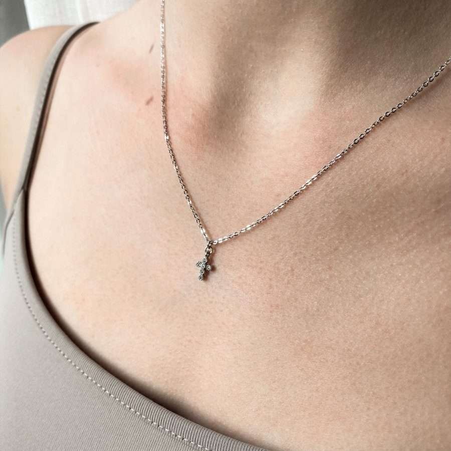 Elegante christliche Kette SAVED BY GRACE aus 925 Sterling Silber mit Kreuzanhänger und Glitzersteinchen um den Hals getragen.