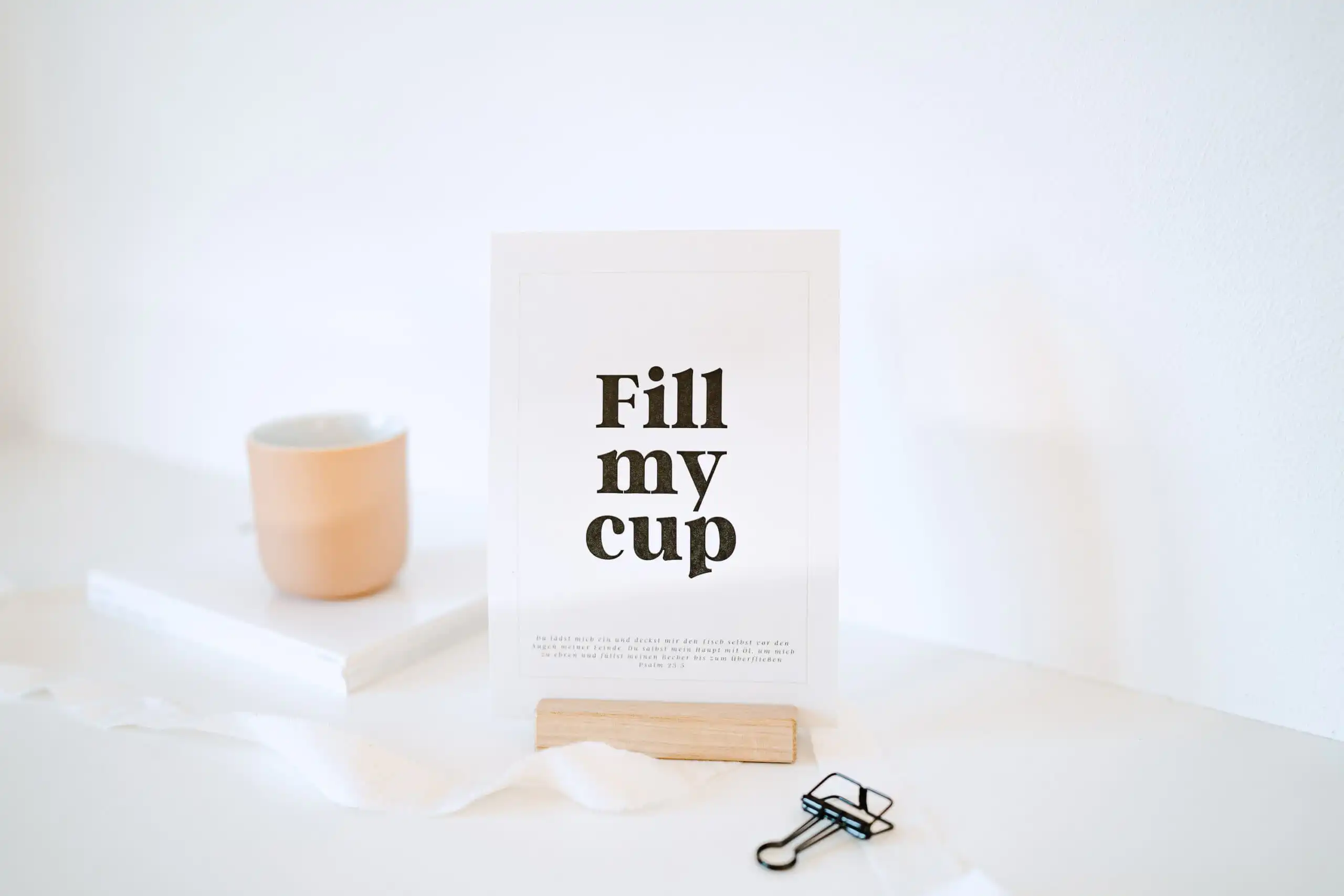 Moderner Christlicher Beistelltisch mit Keramikbecher und Gebetskarte.