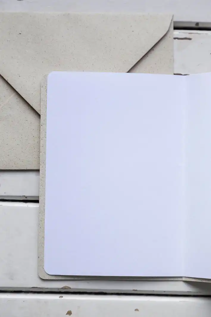 Klappkarte A6 Gänseblümchen 4 Leere christliche Grußkarte mit Umschlag auf weißem Holz-Schreibtisch.