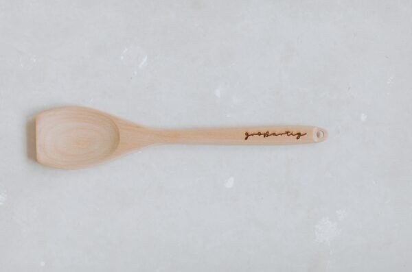 Natur Holz Kochlöffel mit persönliche Gravur auf weißem Hintergrund.