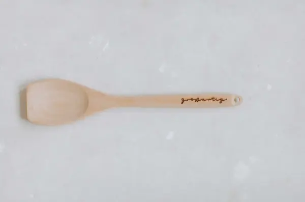 Natur Holz Kochlöffel mit persönliche Gravur auf weißem Hintergrund.