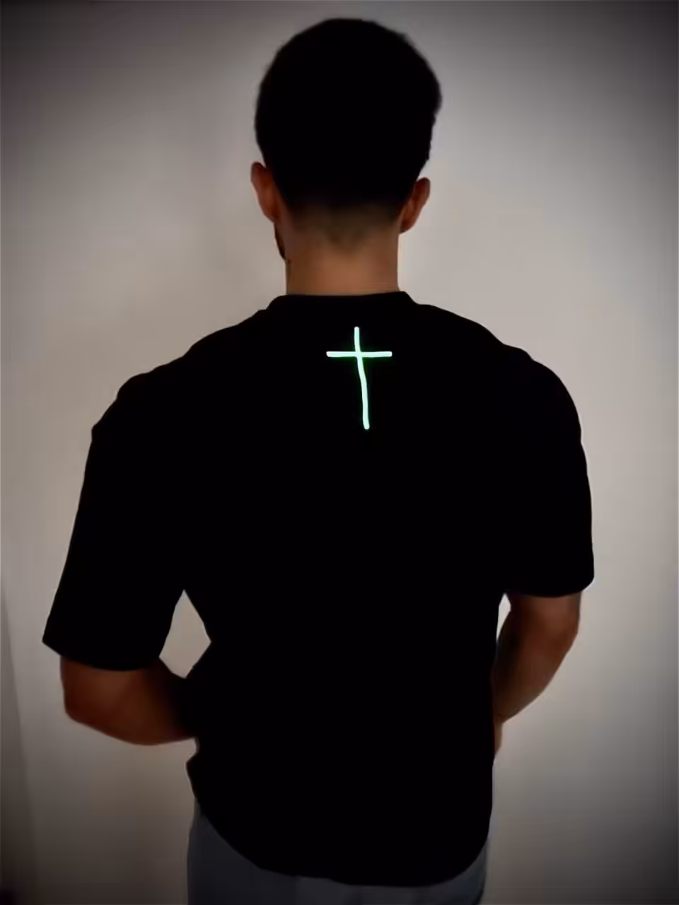 Leuchtendes Kreuz auf schwarzem T-Shirt, christliches Symbol, Glaube, Mode, Glow-in-the-Dark.