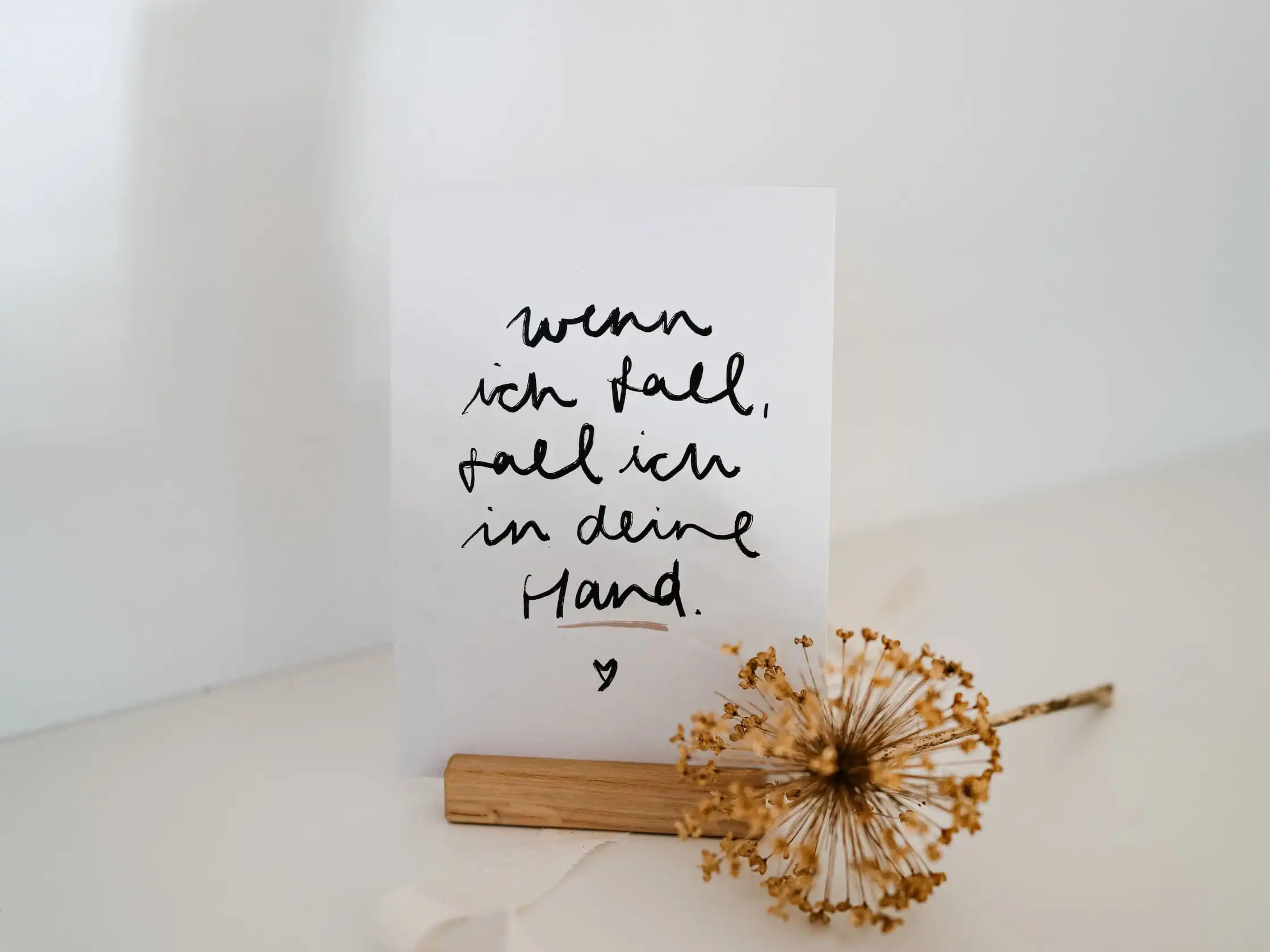 Inspirierende christliche Zitate auf handgeschriebenem Papier, Deko mit Trockenblume.
