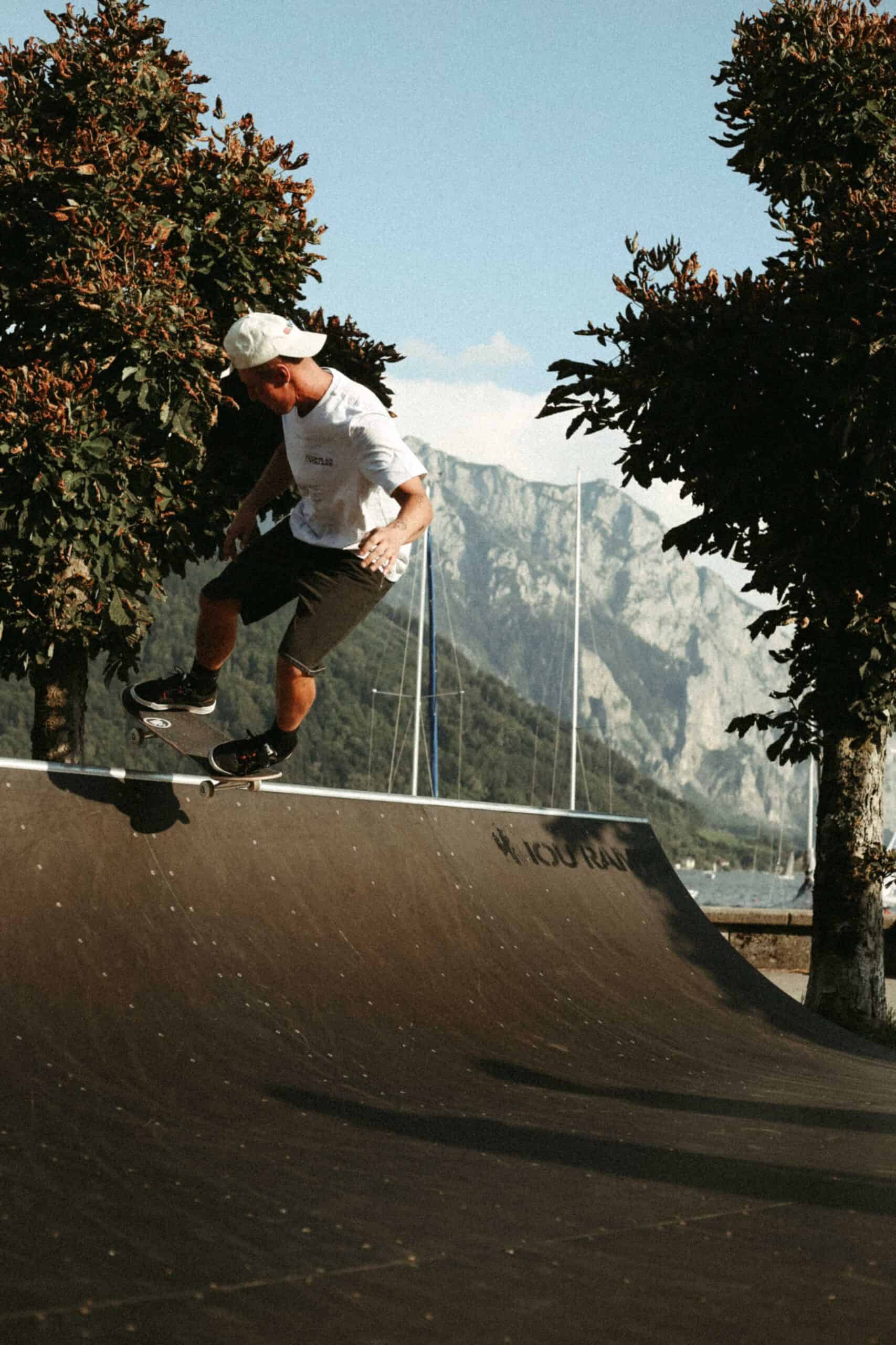 COME AS YOU ARE T-SHIRT GRAU 2 Skateboarder beim Trick auf dem Skatepark mit Natur- und Bergblick in Hintergrund.
