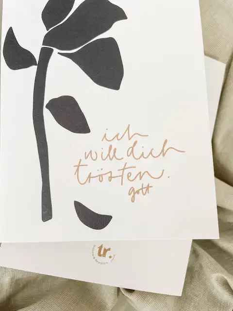 Trauriges Blätterkunstwerk mit tröstendem christlichem Spruch.