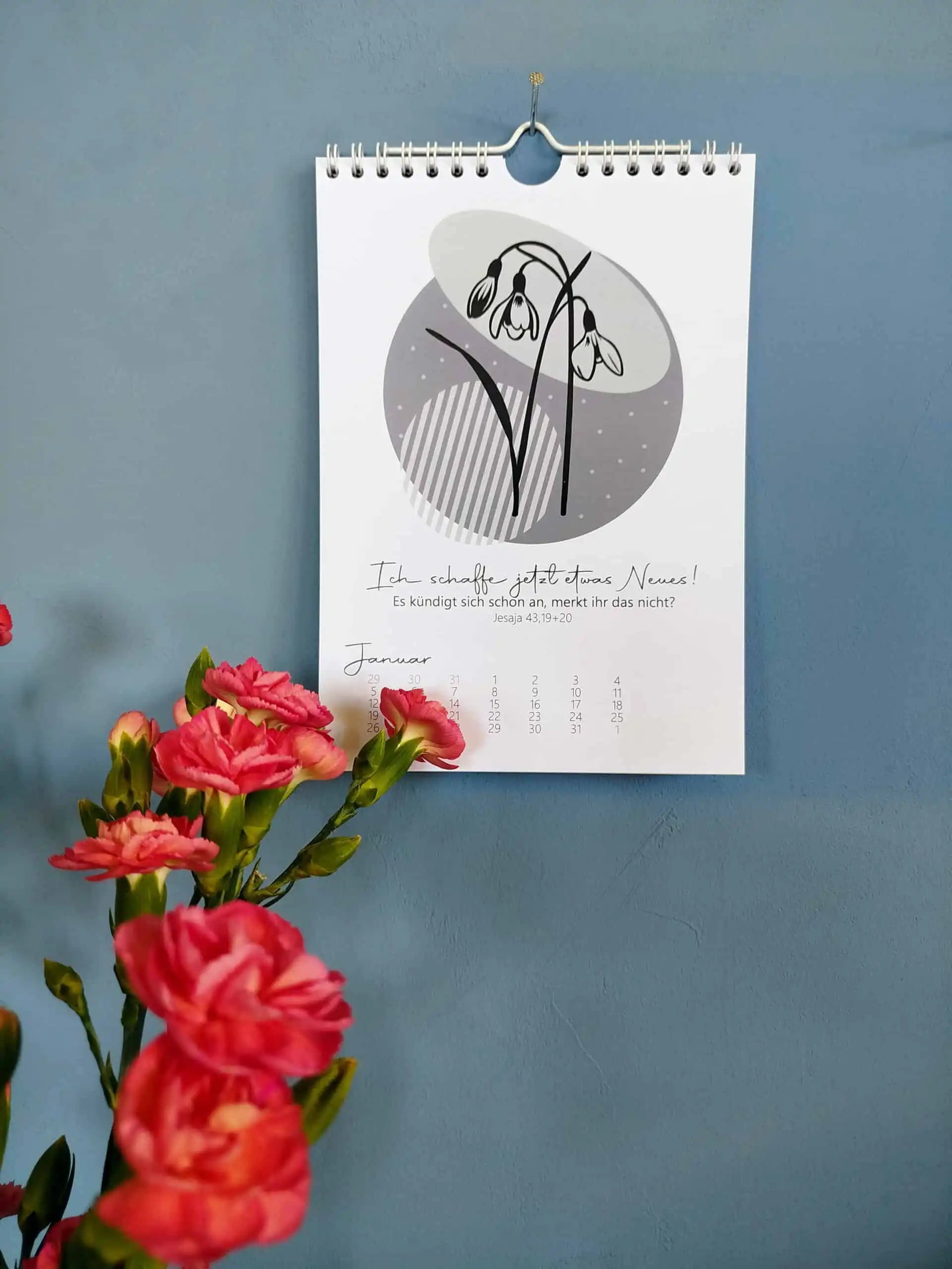 Blumenkalender DinA5 3 Gebetskalender mit christlichem Motiv an blauer Wand, inspirierende religiöse Wandkunst.