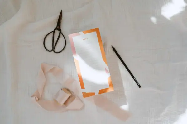 Schere und Marker auf Stoff mit To-Do-Liste für christliche Inspiration.