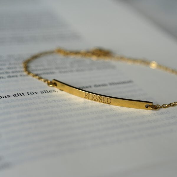 Goldene Halskette mit „Blessed“-Schriftzug, christliches Schmuckstück, spiritueller Schmuck.