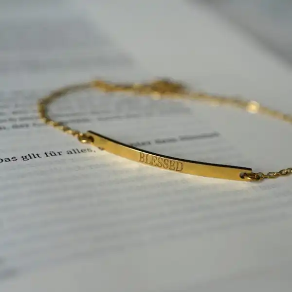 Goldene Halskette mit „Blessed“-Schriftzug, christliches Schmuckstück, spiritueller Schmuck.