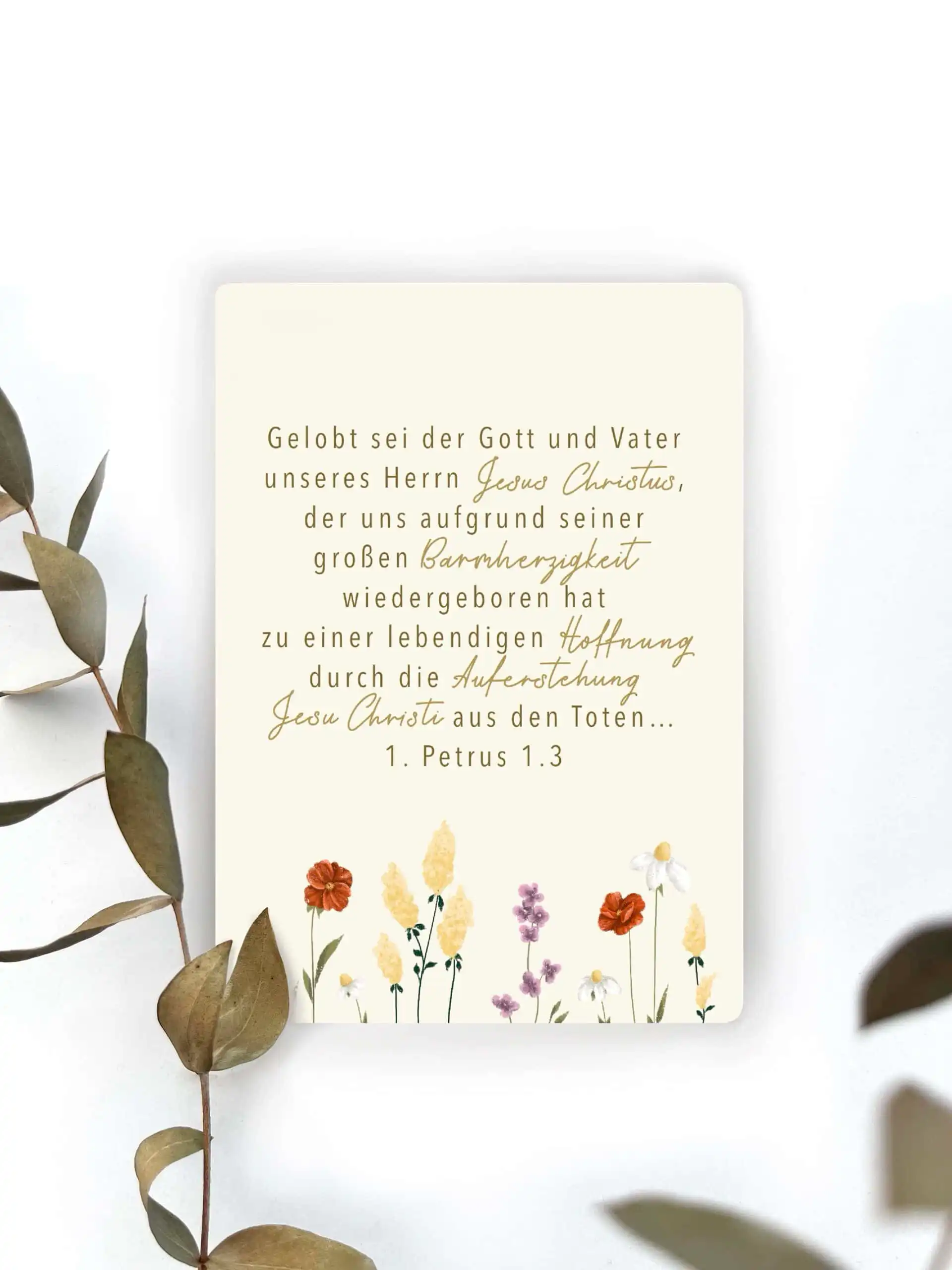 Tageslosung mit Bibelvers aus 1. Petrus 1.3, dekorativ mit Blumen und Eukalyptus verziert.