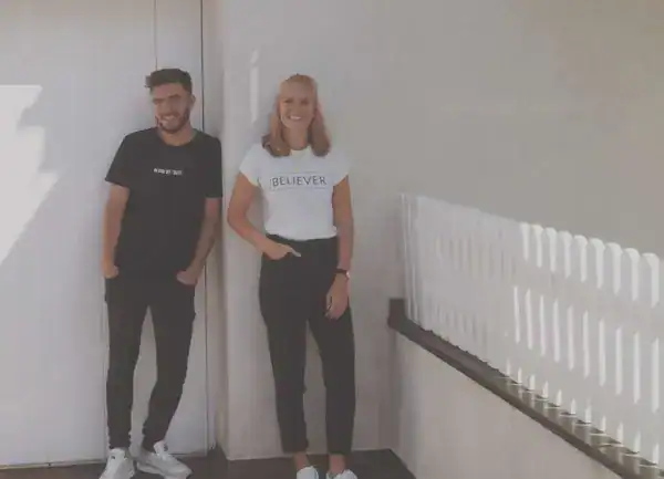 Lächelnde junge Menschen auf modernem Balkon mit Heizung, urbanes Lifestyle Bild.