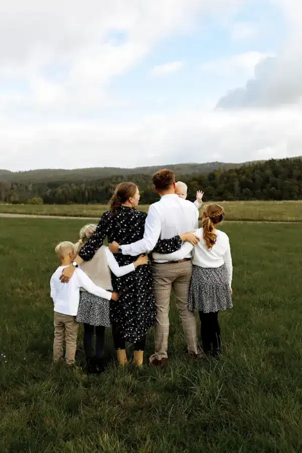 Familie im Grünen, idyllischer Landschaftsausflug, gemeinsames Familienfoto, Naturerlebnis, ländliche Umgebung.