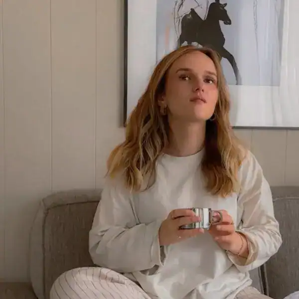 Gemütliche Frau mit Tasse im Wohnzimmer, entspanne Atmosphäre.