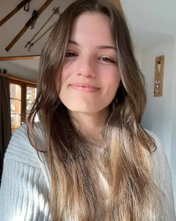 Hübsches junges Mädchen mit langen braunen Haaren, natürliches Licht, kuschelige Atmosphäre, Lifestyle-Foto.