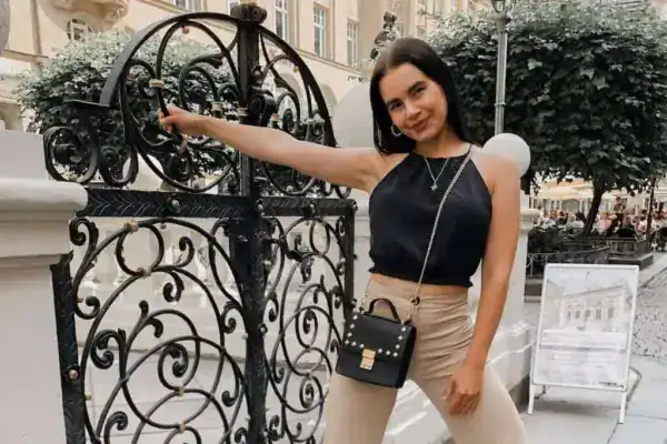 Stadttouristin posierend an ornate Schmiedeeisen-Zaun in Innenstadt de_DE.