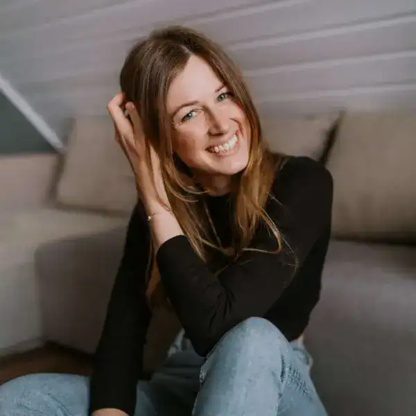 Fröhliche junge Frau lacht beim entspannten Fotoshooting.