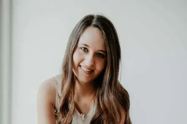 Hübsche junge Frau mit langen braunen Haaren und einem freundlichen Lächeln.