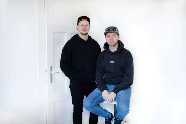 Jungs in schwarzen Hoodies vor weißer Wand, moderner Streetwear, muslimischer Stil, Mode, Jugendlichen.