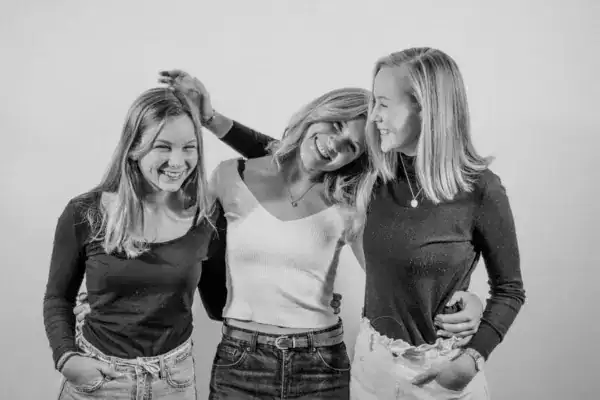 Lebende Frauen lachen zusammen bei Freundinnen-Treffen, Freude und Freundschaft.