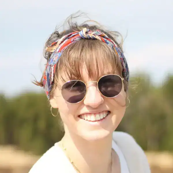 Farbenfrohe Frau mit Sonnenbrille und Bandana, sommerliches Stylebild.
