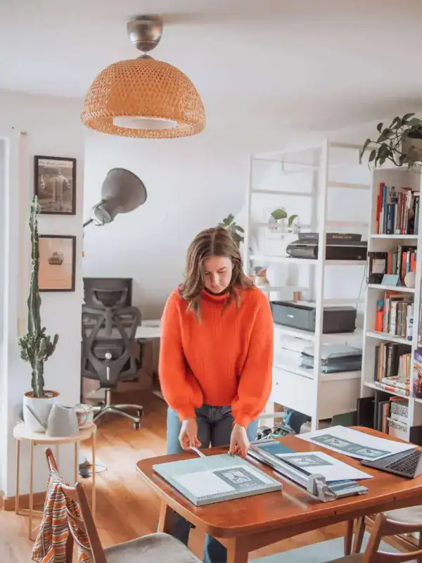 Gemütliches Arbeitszimmer mit modernes Design, Frau beim Sortieren von Dokumenten, kreative Studiosituation, Produktivitätsumgebung, Homeoffice.