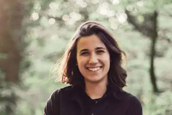 Lächelnde junge Frau im Grünen Naturpark, glückliches Gesicht, authentischer Portrait.