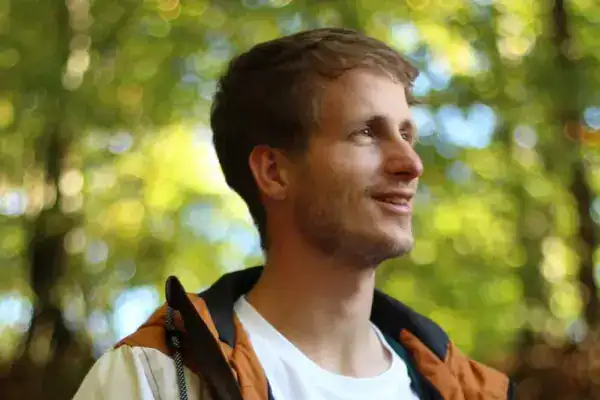 Nature Bilder mit lachendem Mann im Wald, entspannte Atmosphäre, Outdoor, Sonnenlicht, Freizeit, Abenteuer.