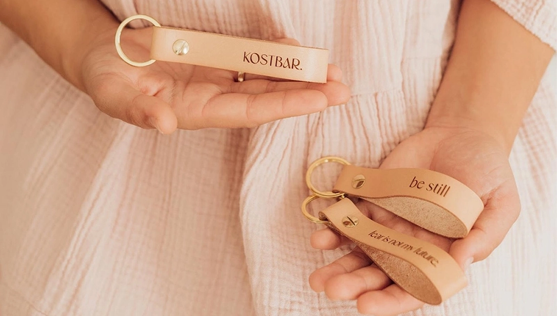 Person hält christliche Schlüsselanhänger aus Leder in der Hand