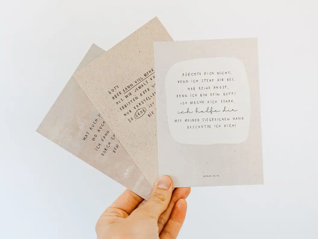 Christliche Karten werden von einer Hand hochgehalten