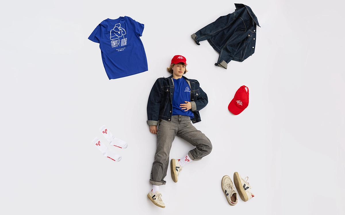 Mädchen liegt mit verschiedener christlicher Kleidung auf weißem Boden