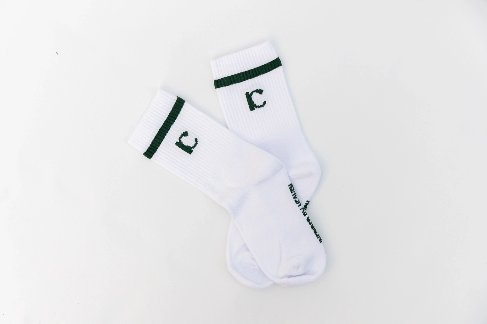 Weiße Socken mit schwarzen Linien liegen auf einem weißen Boden