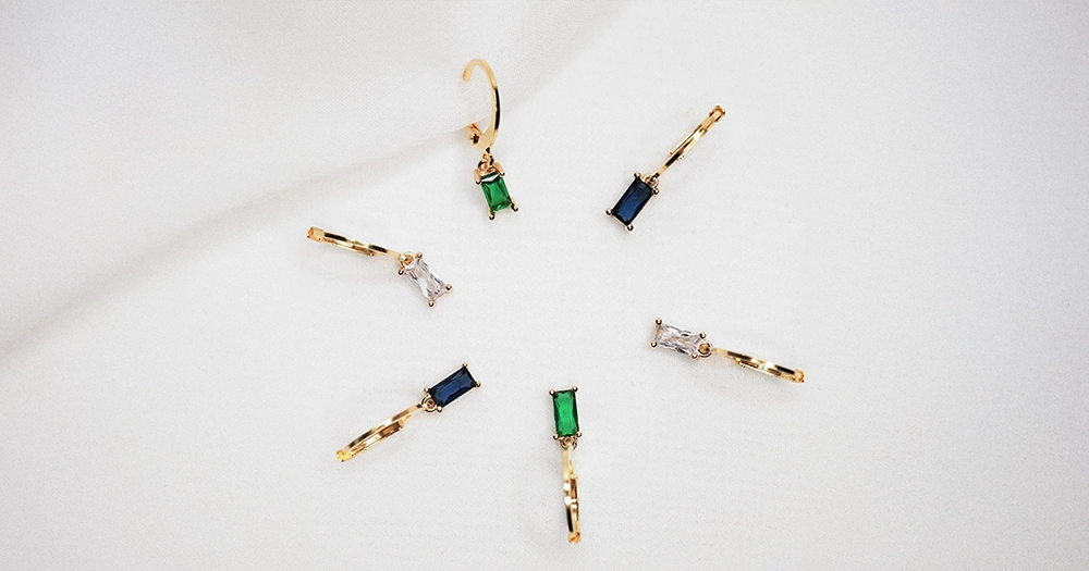 Unterschiedliche goldene Hoops liegen auf einem weißen Tuch