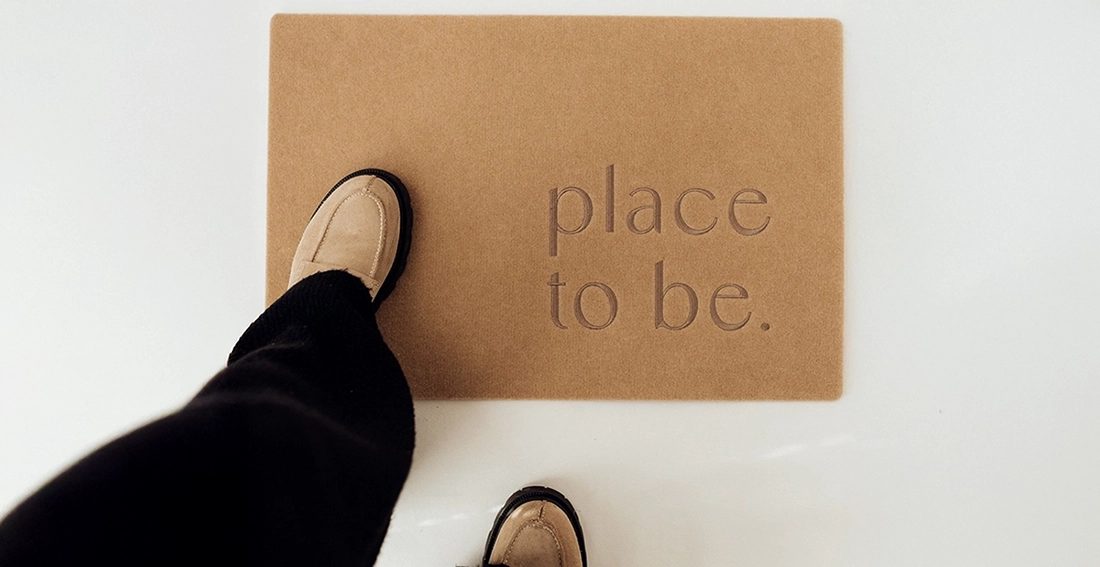 Person steht auf christlicher Fußmatte mit Spruch