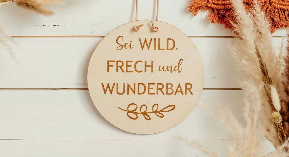 Christliche Holzscheibe mit Spruch hängt an der Wand