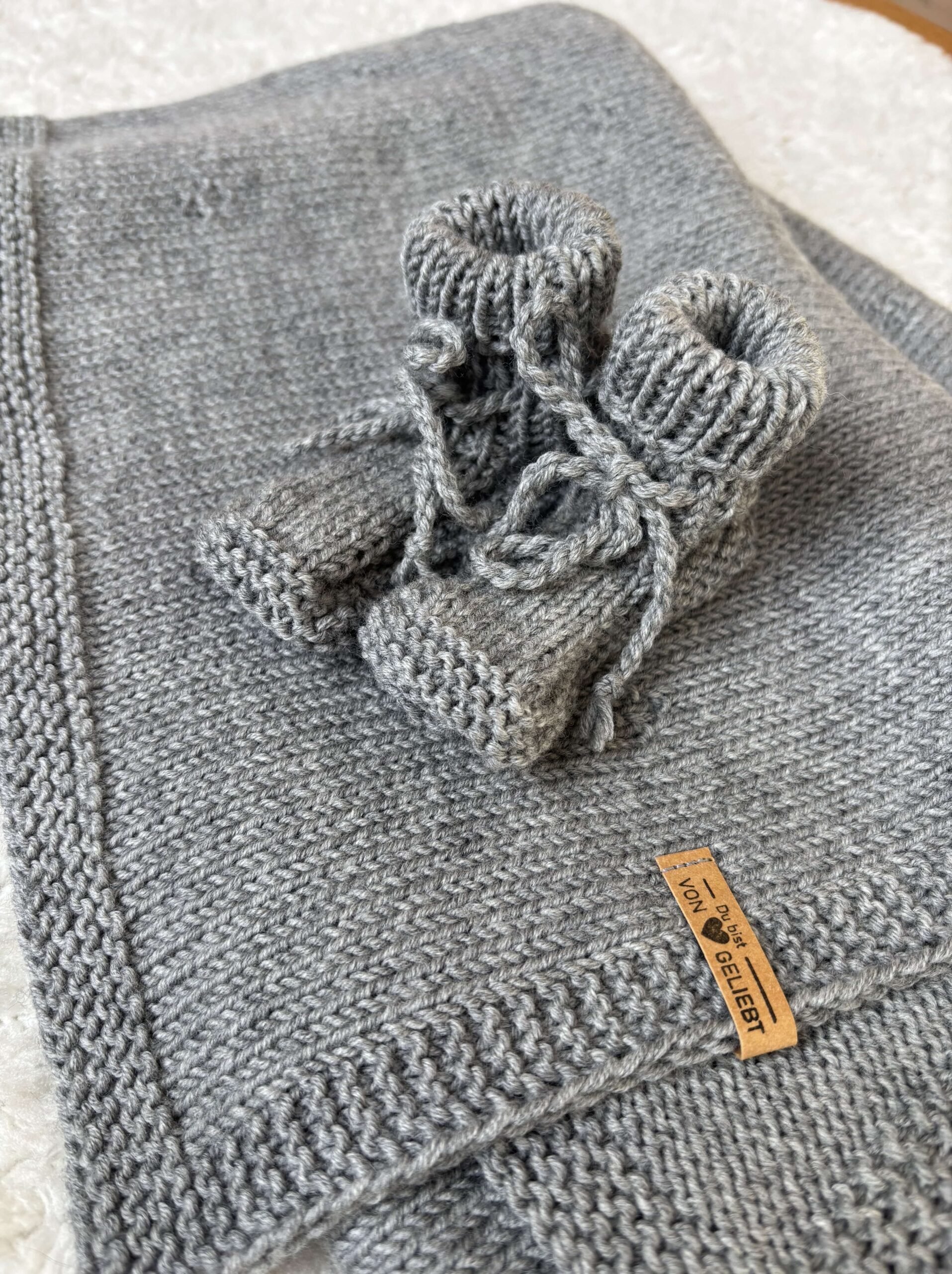 Handgestrickte graue Socken auf Wolldecken, christliche Geschenkidee, Gebet & Glaube.