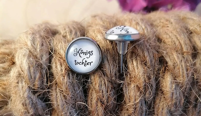 Runder Ohrstecker ‚Königstochter‘ steckt in einem geknoteten Tau