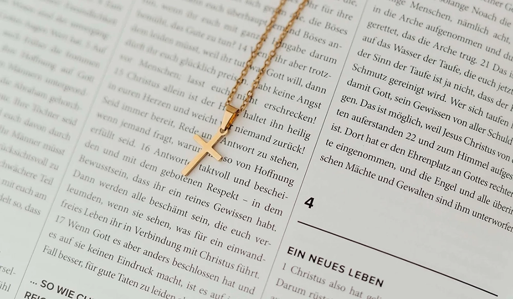 goldene Kreuzkette liegt auf einem offener Bibel