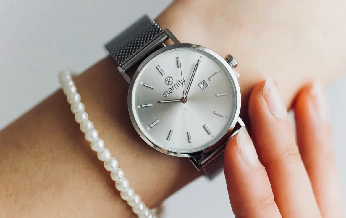 Silberne christliche Uhr wird am Arm getragen und eingestellt