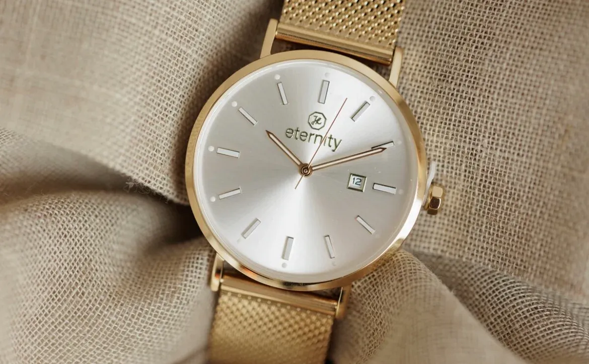 Goldene christliche Uhr liegt auf einem beigen Tuch