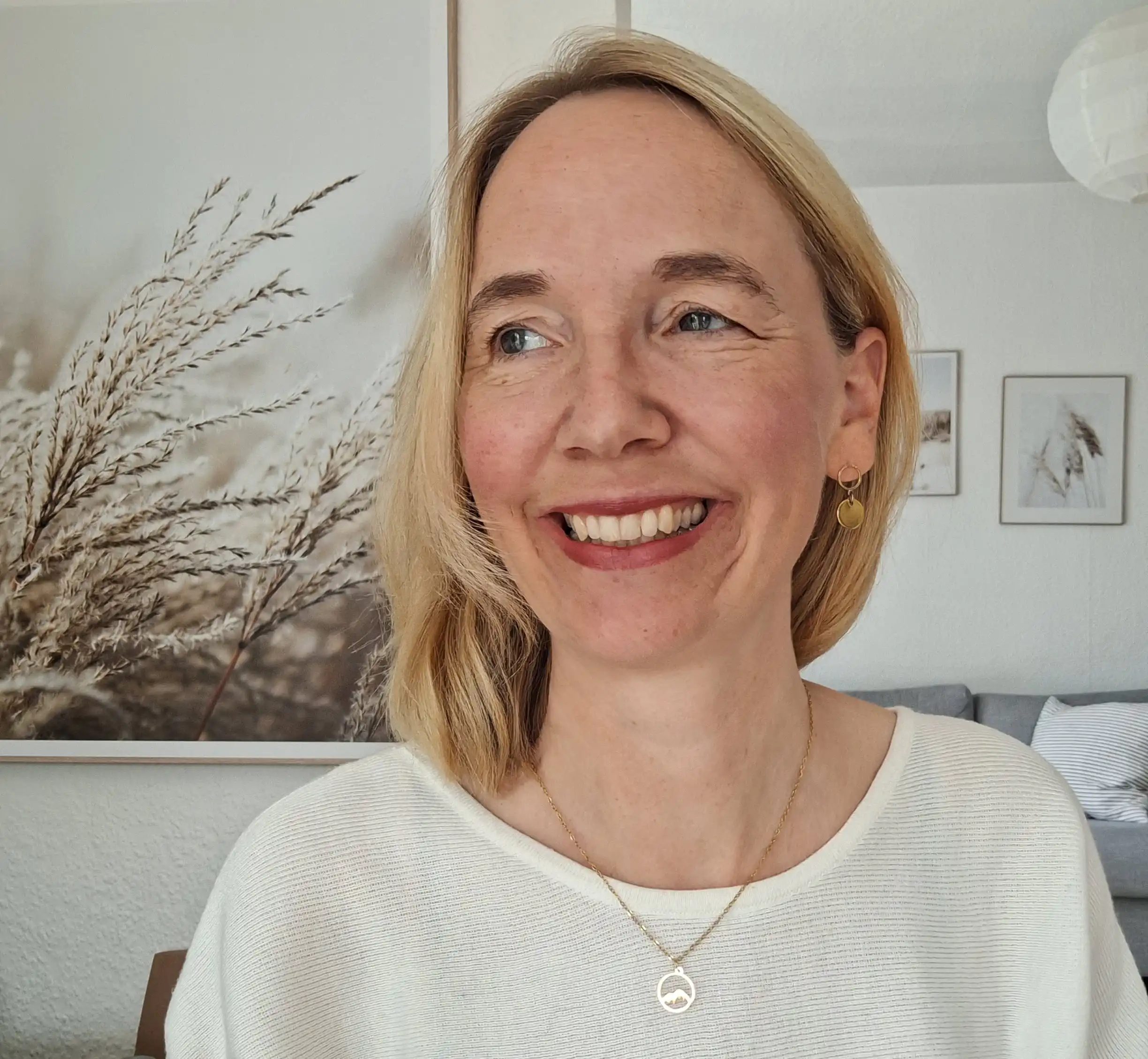 Goldkette "ich hebe meine Augen auf zu den Bergen" 4 Gottesdienstfrau lächelnd in modernem Wohnzimmer, christliche Inspiration, positive Stimmung.